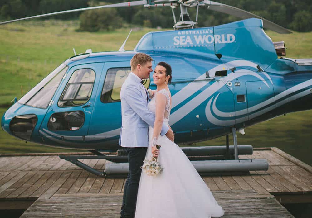 Bride and groom beside helicopter after Gold Coast wedding flight